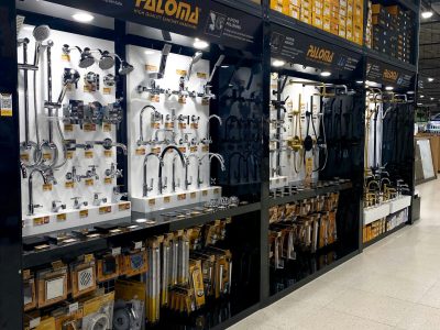 Shelves showcasing a variety of plumbing fixtures, faucets, and tools in a hardware store.